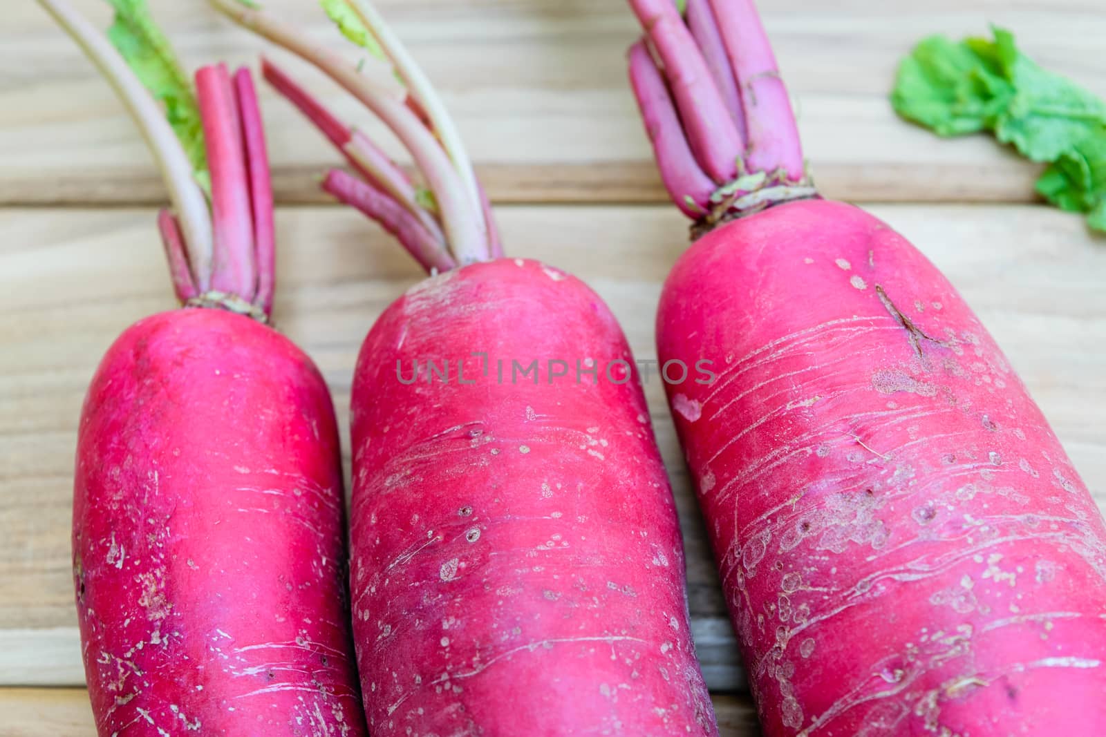 Red radish on wooden table by naramit