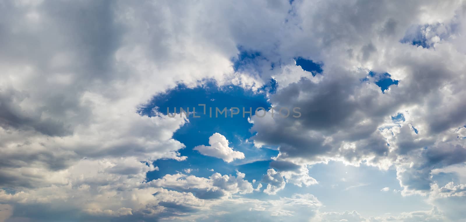 Panorama of the sky with cumulus and storm clouds in a spring afternoon
