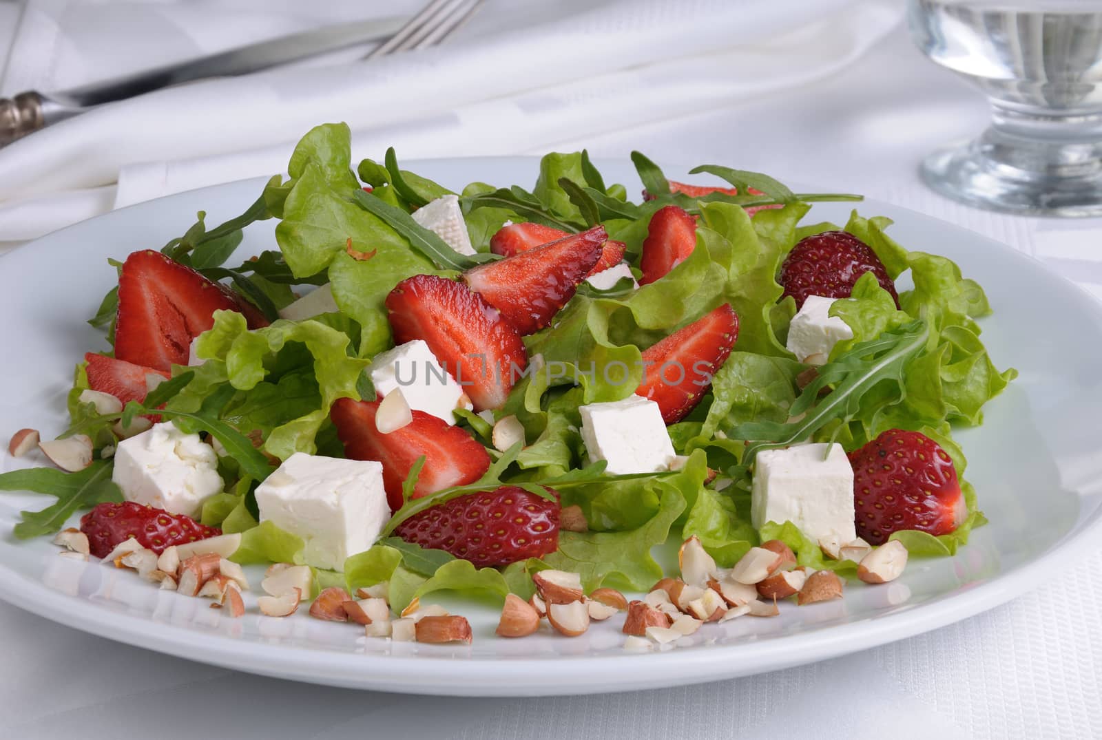 Salad of lettuce, arugula, strawberries, feta cheese and peanuts