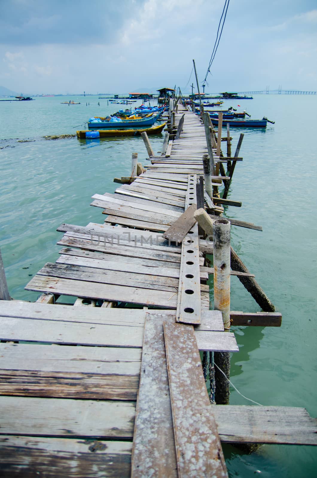 Wooden pier on the sea background, destroyed bridge near tropics. Color panorama