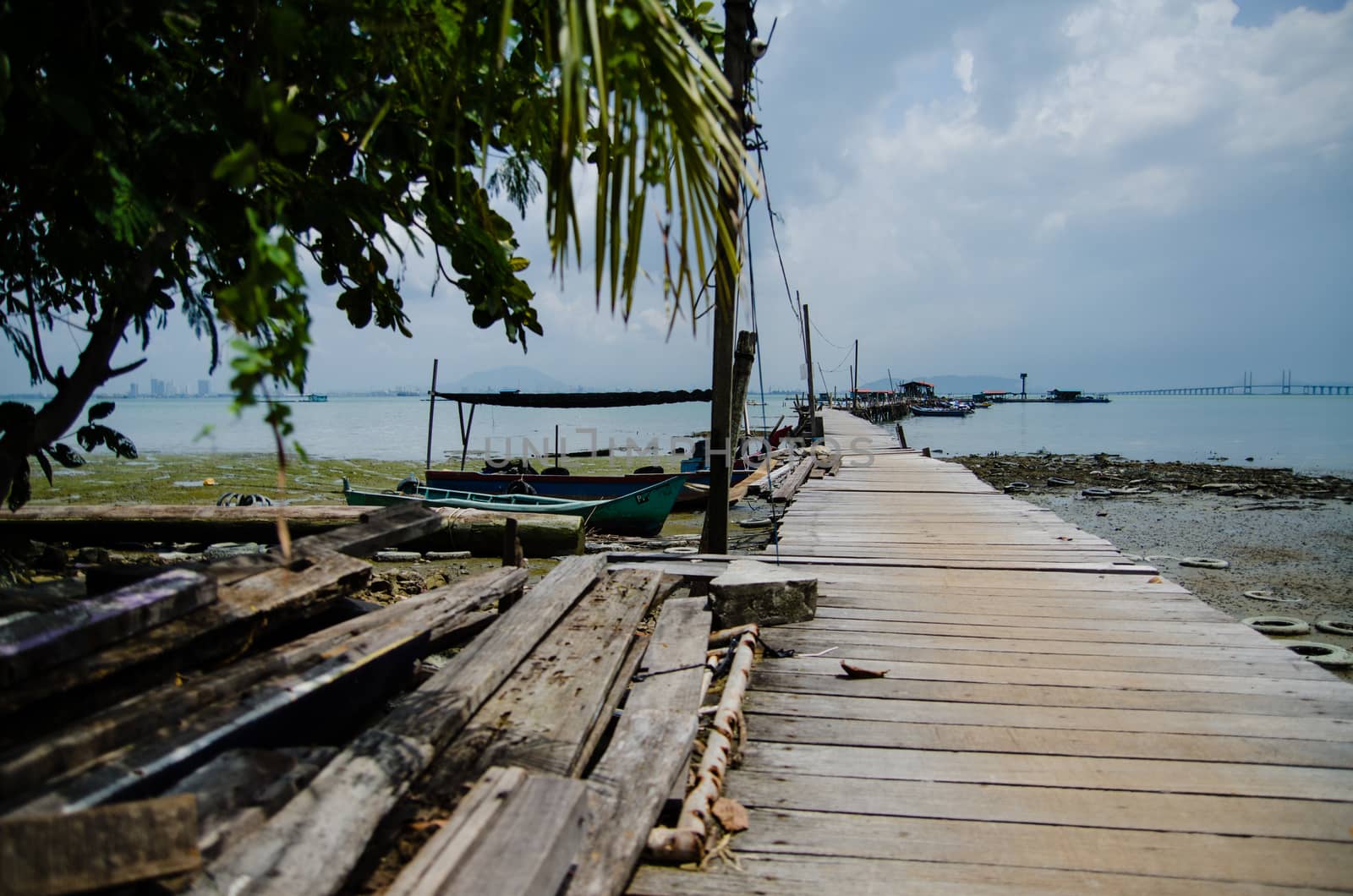 Wooden pier on the sea background, destroyed bridge near tropics. Color panorama