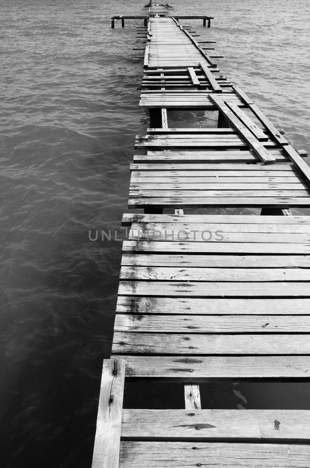 Penang island Malaysia. Wooden pier on the sea background, destroyed bridge near tropics. Black and white panorama