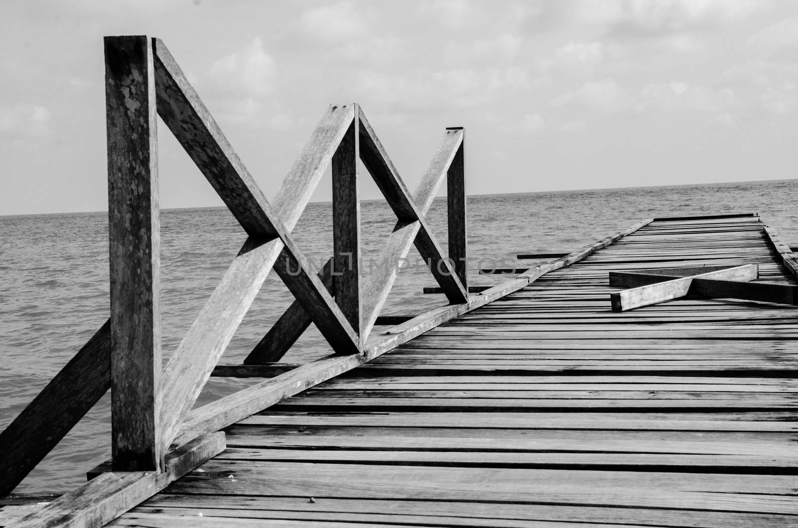 Penang island Malaysia. Wooden pier on the sea background, destroyed bridge near tropics. Black and white panorama