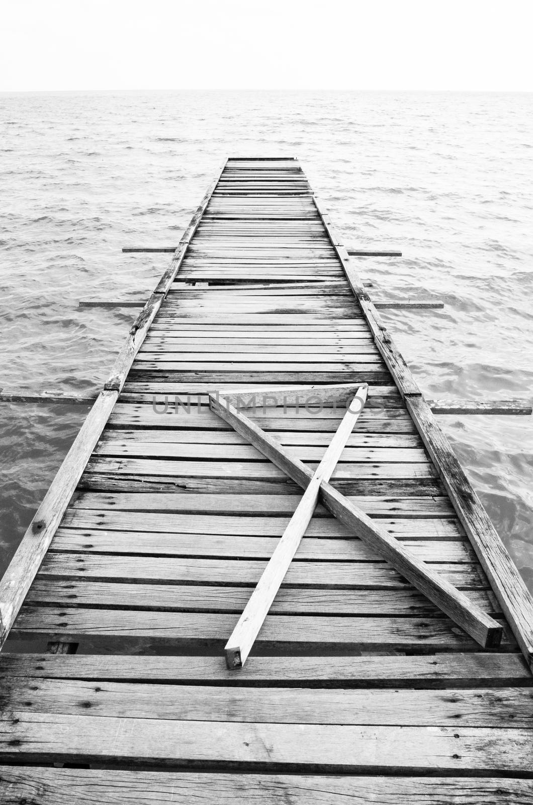 Penang island Malaysia. Wooden pier on the sea background, destroyed bridge near tropics. Black and white panorama