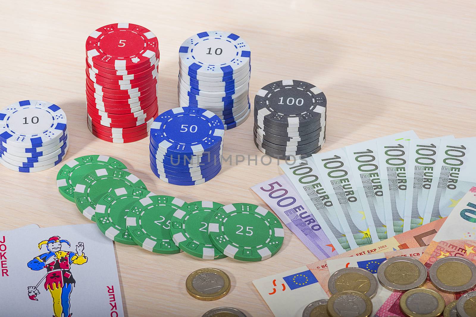 Multi-colored casino chips and money won on the game of gambling