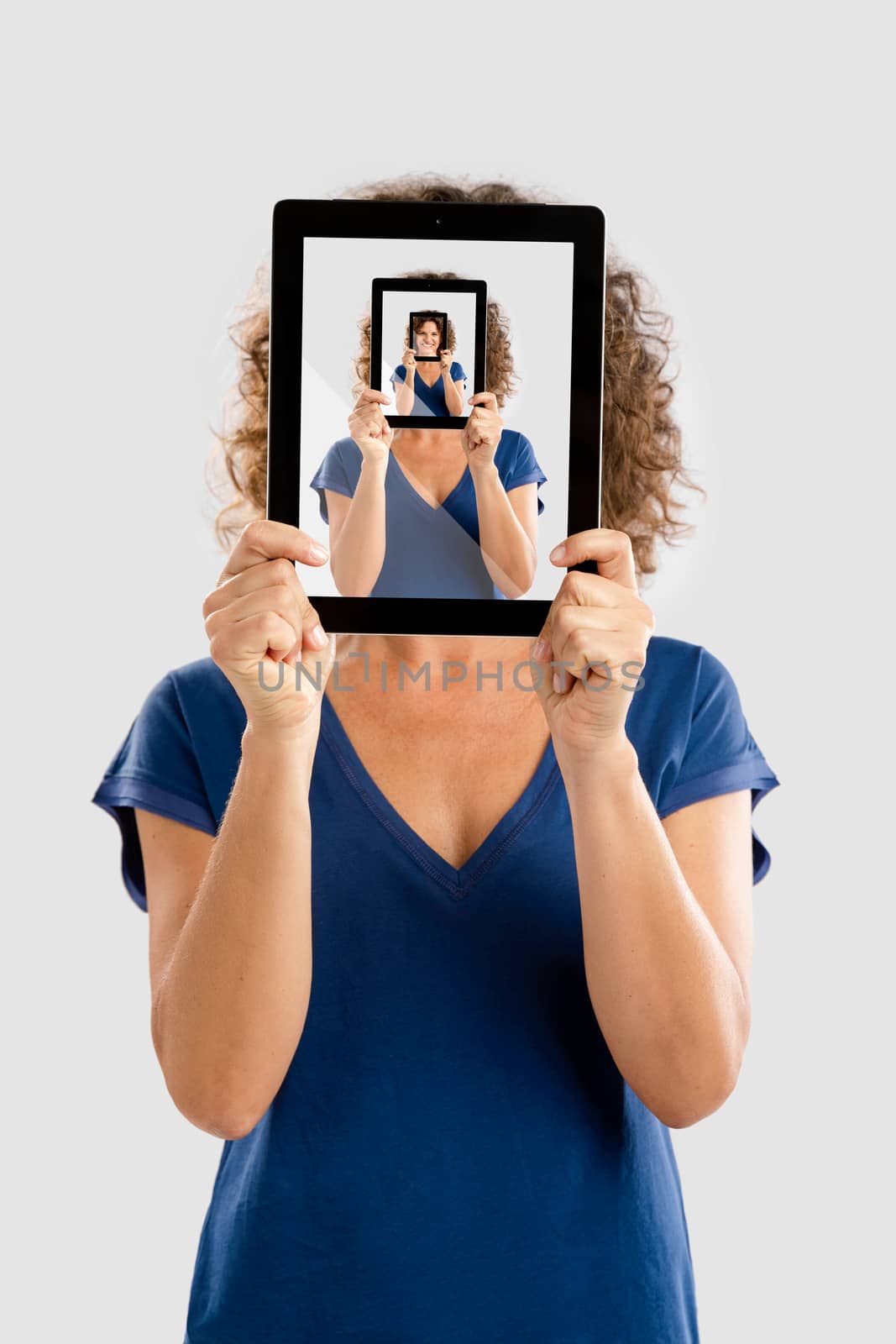 Woman holding a tablet and cover her face