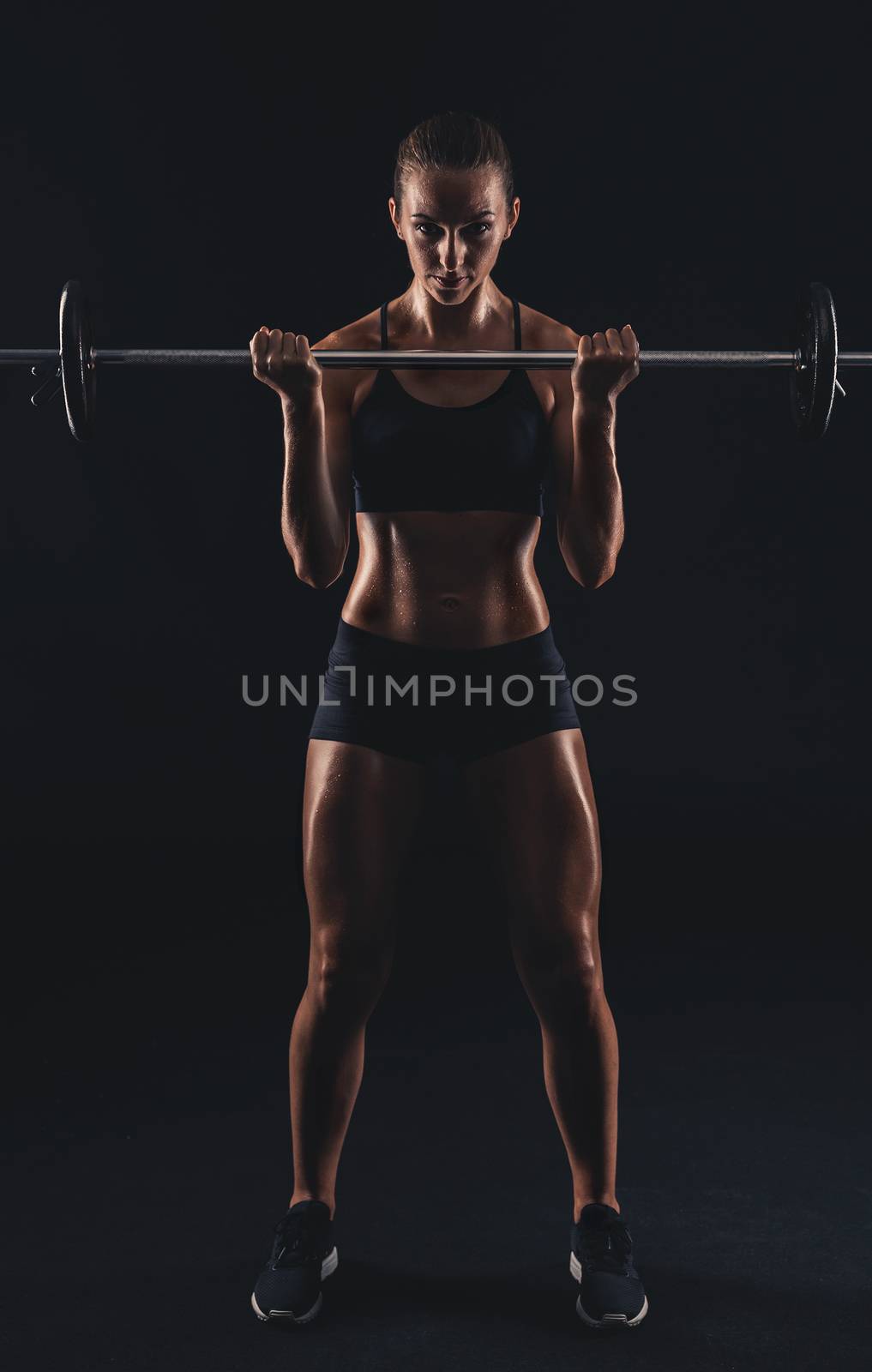 Shot of a beautiful young woman in a workout gear lifting weights