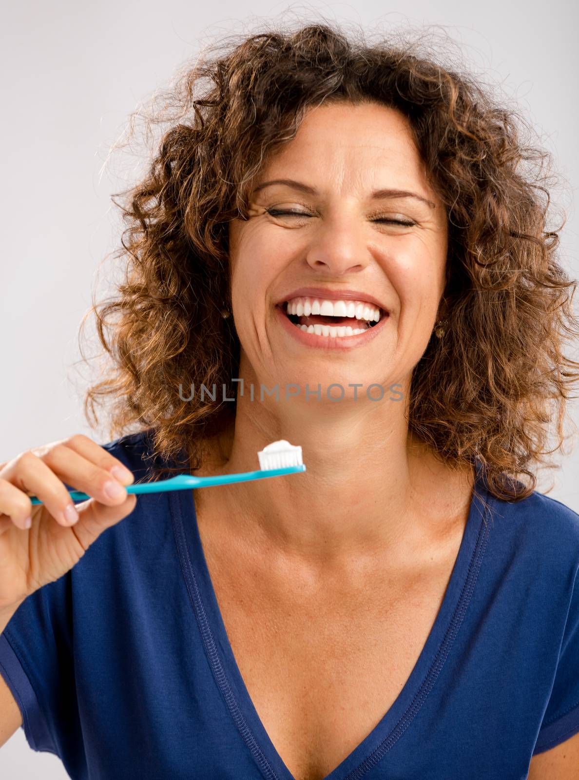 Beautiful mature woman brushing her teeths 