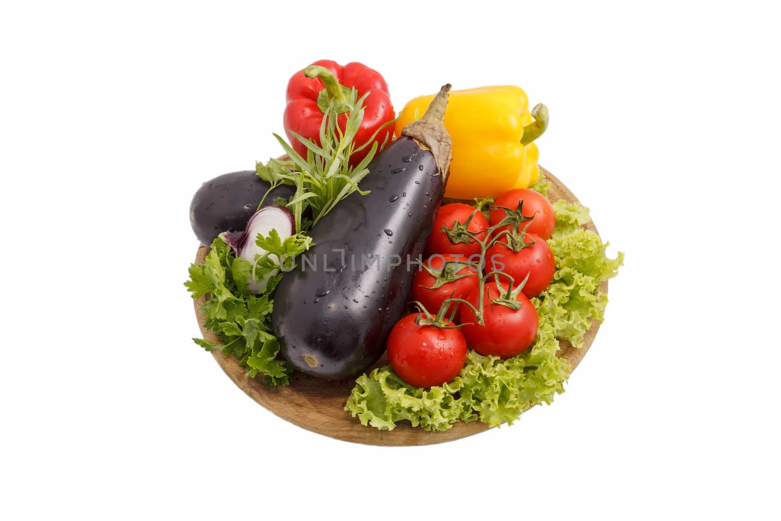 Red, yellow paprika of a paprika, tomatoes and eggplants on a round wooden board. Healthy, food food subject. Top view