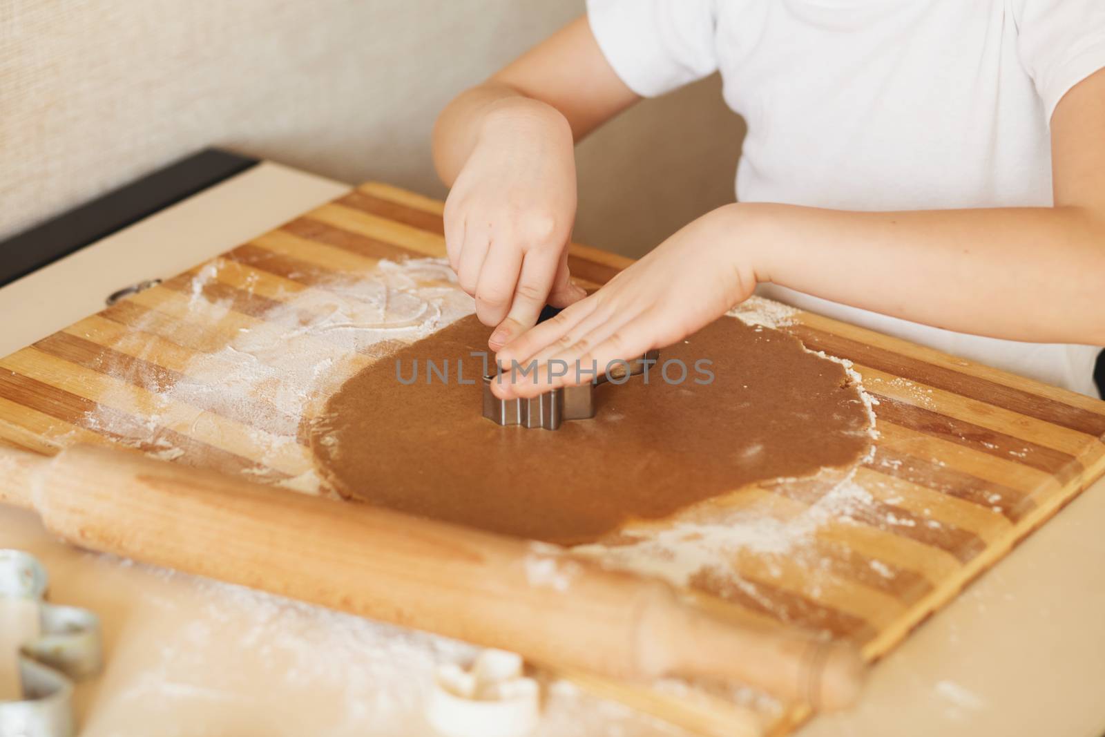 Master class for children on baking christmas cookies. Young children learn to cook a honey-cake. Kids preparing homemade gingerbread. Little cook.