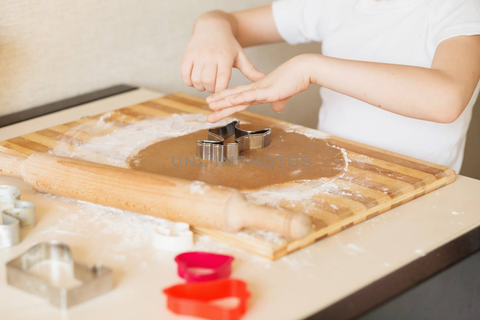 Master class for children on baking christmas cookies. Young children learn to cook a honey-cake. Kids preparing homemade gingerbread. Little cook.