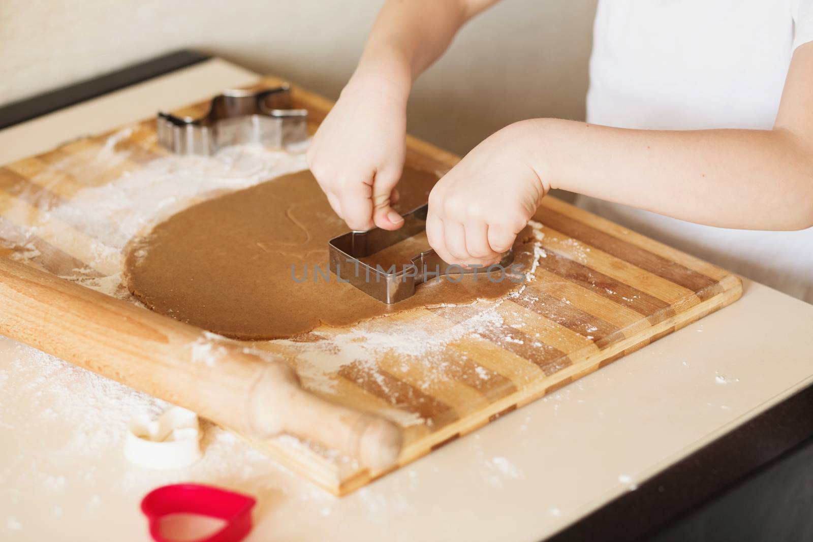 Master class for children on baking christmas cookies. Young children learn to cook a honey-cake. Kids preparing homemade gingerbread. Little cook.