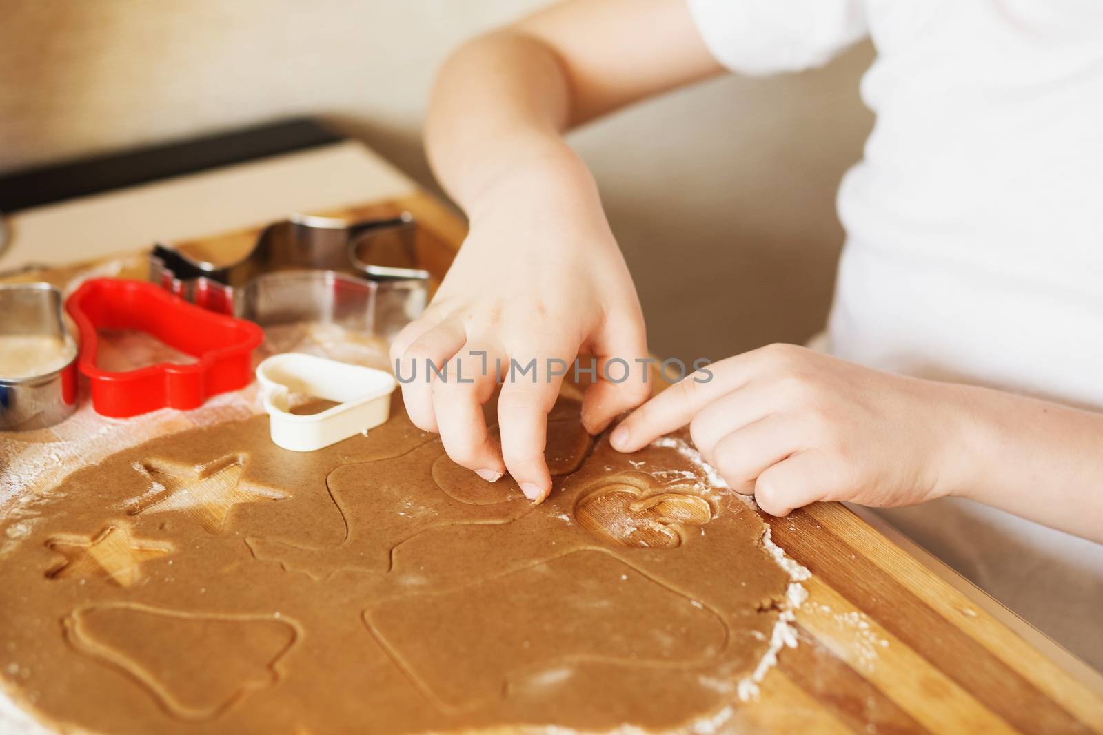 Children's hands make gingerbread. Small boy cutting cookies for Christmas. Kid Baking Cooking Cookies Fun Concept. Master class for children on baking christmas gingerbread.