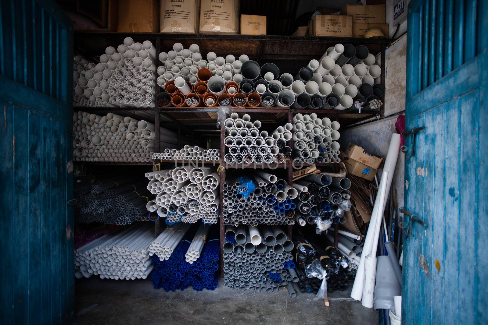 Boxes of grey and white plastic pipes in a warehouse 