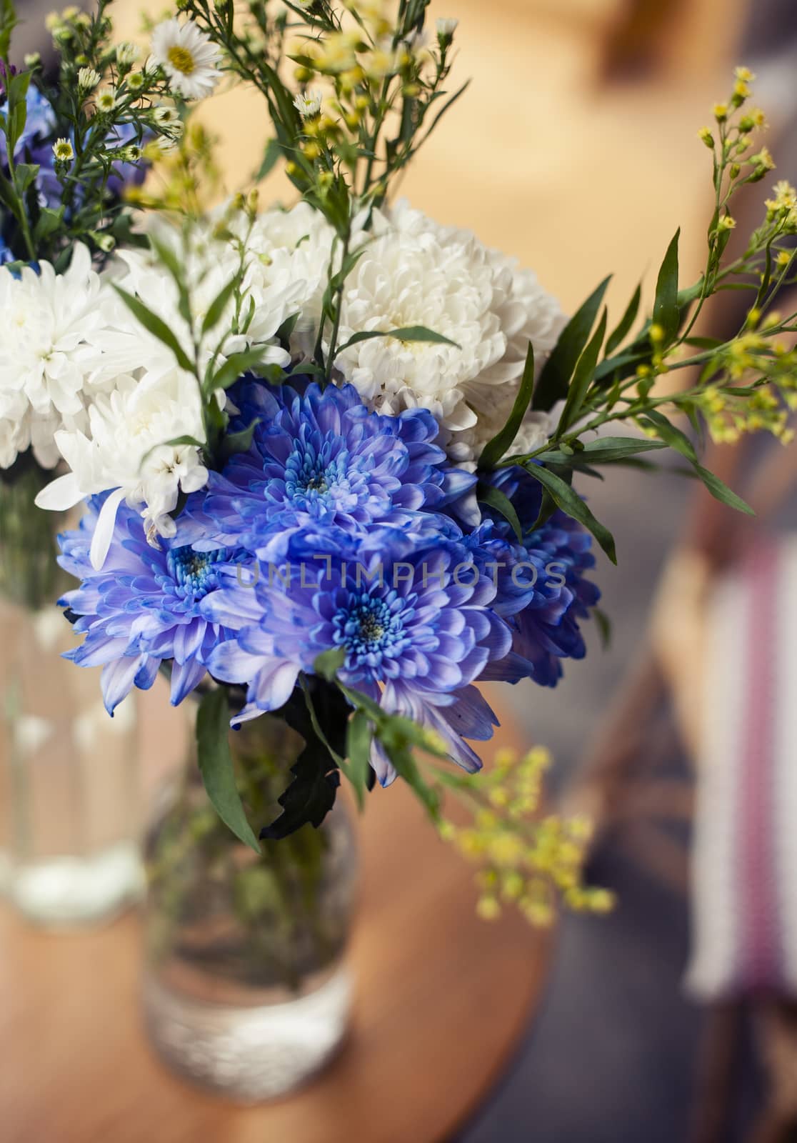 A simple bouquet of flowers in a vase on the pavement close up