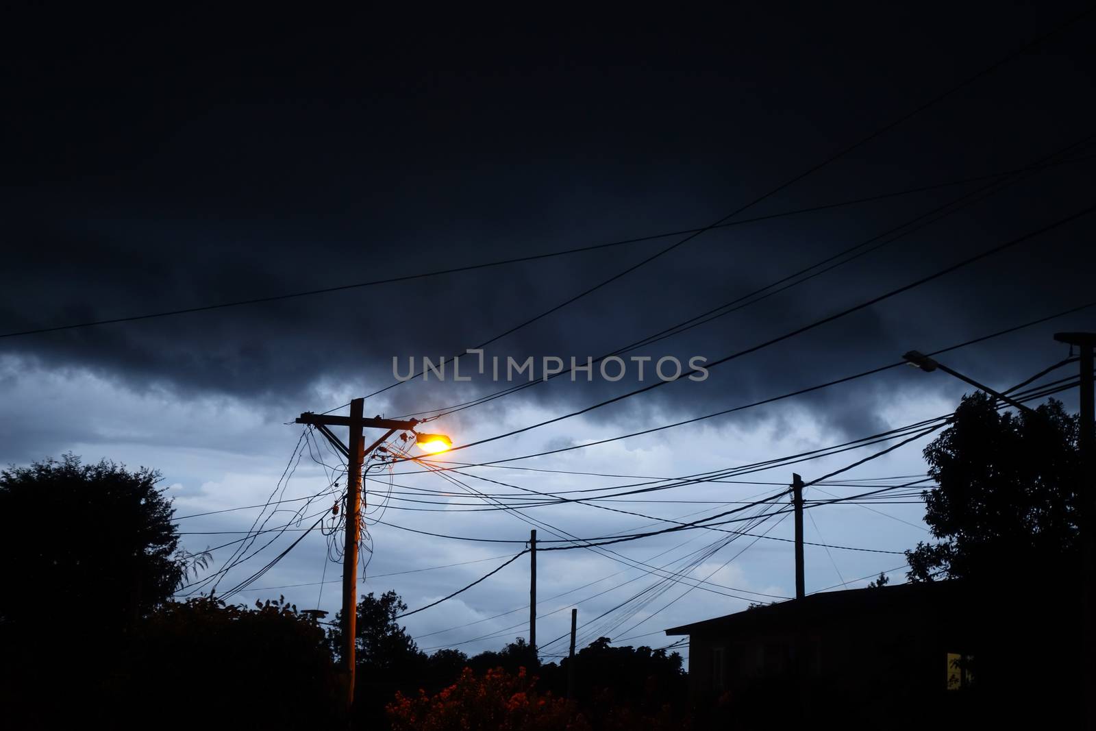Street light at night with a stormy sky background. Dark mystery scene