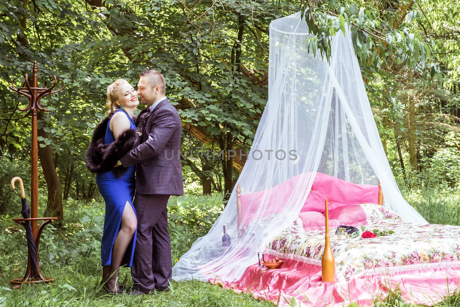 Man and woman standing by the bed and hugging on the lawn in Lviv, Ukraine.