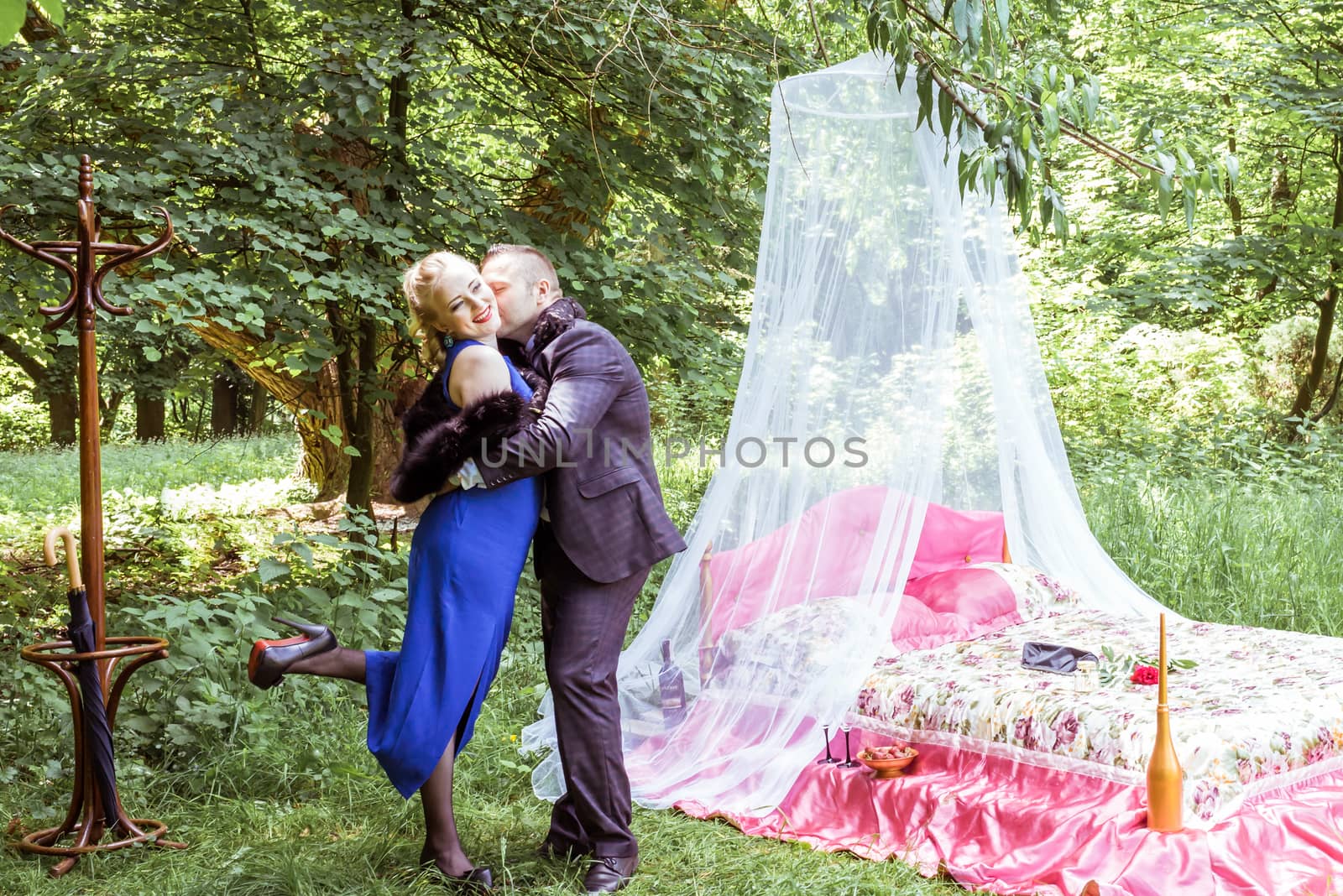 Man and woman standing by the bed and hugging on the lawn in Lviv, Ukraine.