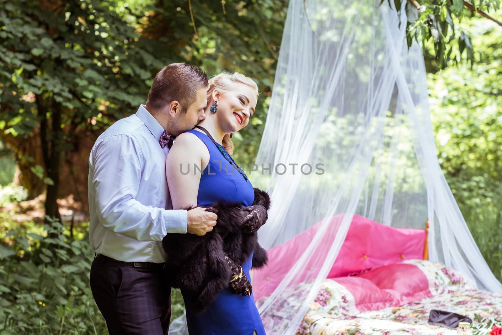 Man and woman standing by the bed and hugging on the lawn in Lviv, Ukraine.