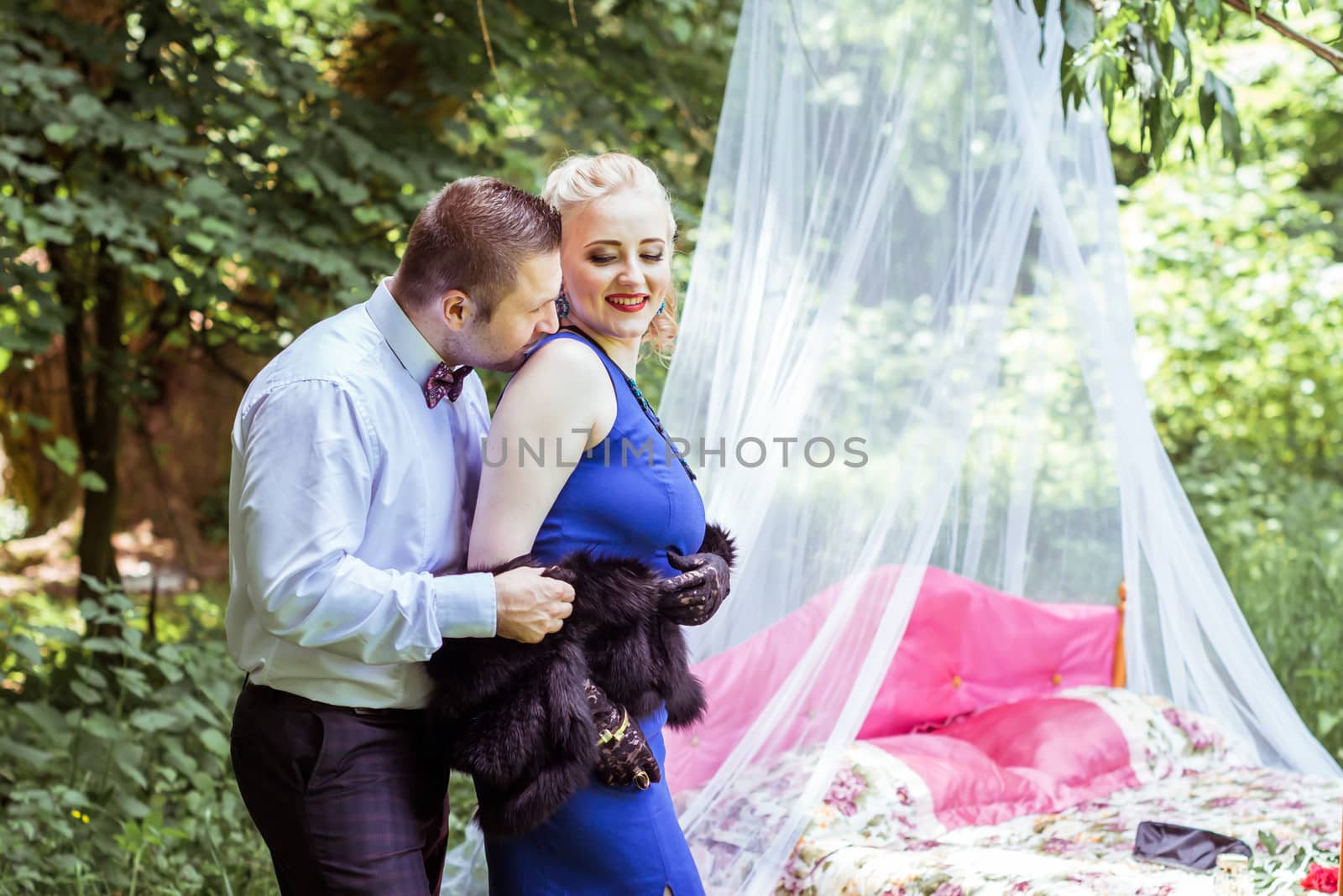 Man and woman standing by the bed and hugging on the lawn in Lviv, Ukraine.