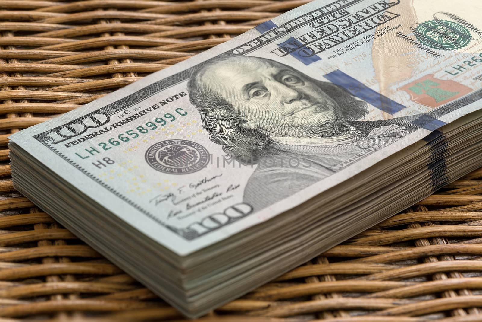 Stack of United States of America USD 100 One Hundred Dollars Federal Reserve Note in a Pile on Wicker Background