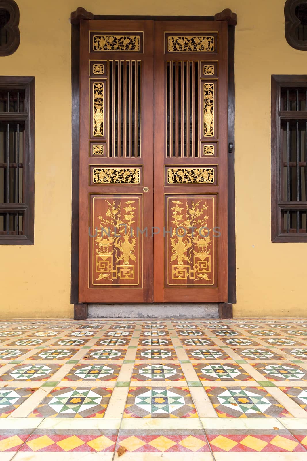 Ornate Doors of Peranakan Style exterior with Chinese wood carvings and colorful tiles entrance