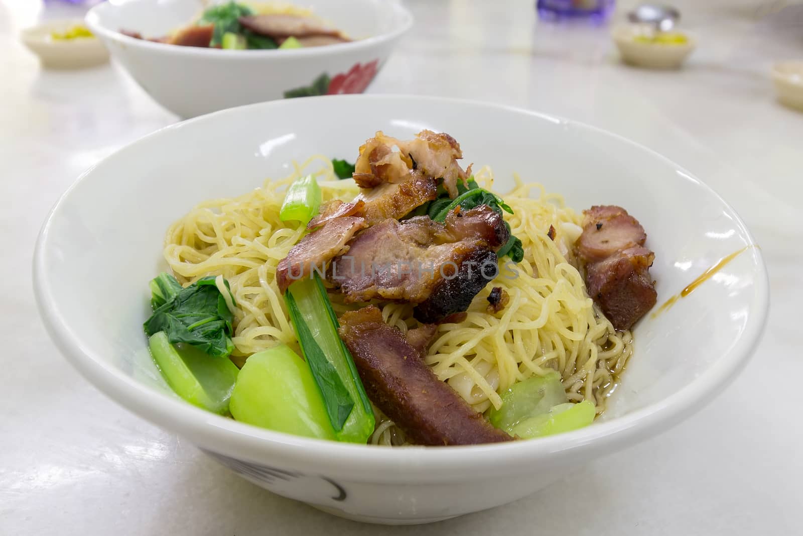 Char Siew Barbecue Pork Wanton Noodles with green vegetable dried on table version closeup macro