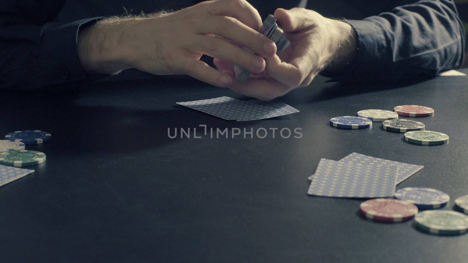 Poker game - dealing cards. Man's hands dealing cards and chips. Close up