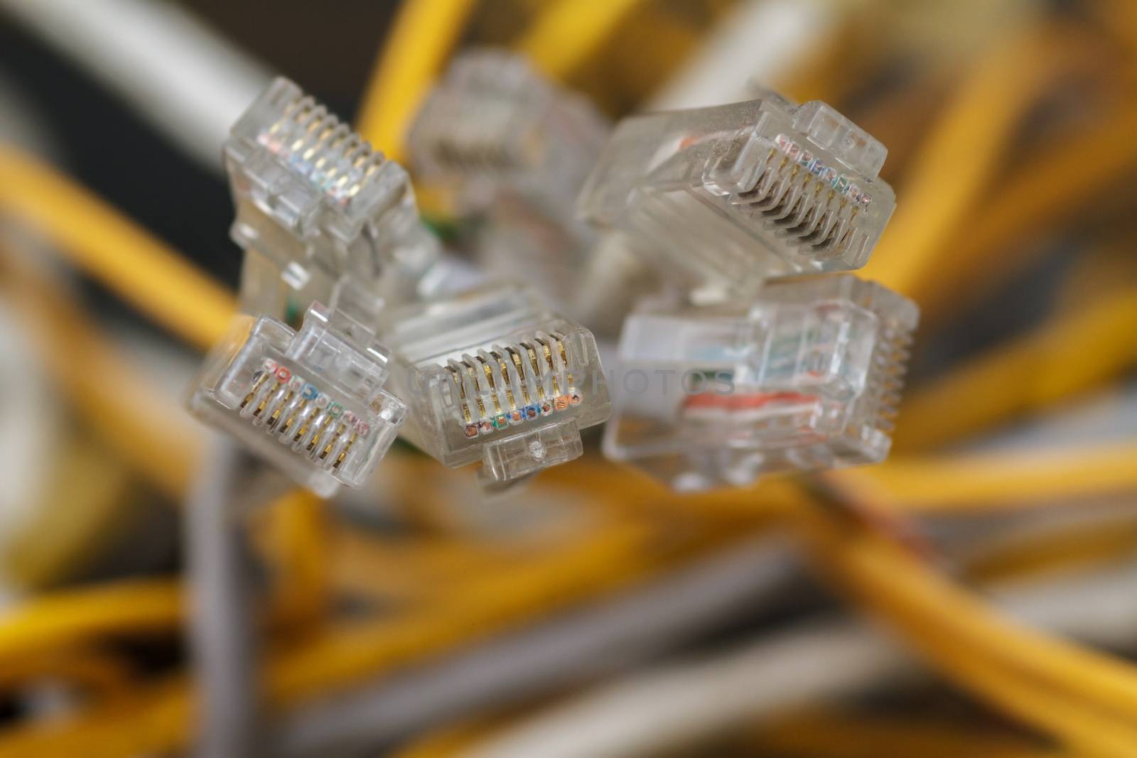 Internet connectors with yellow wires in the background. Close-up