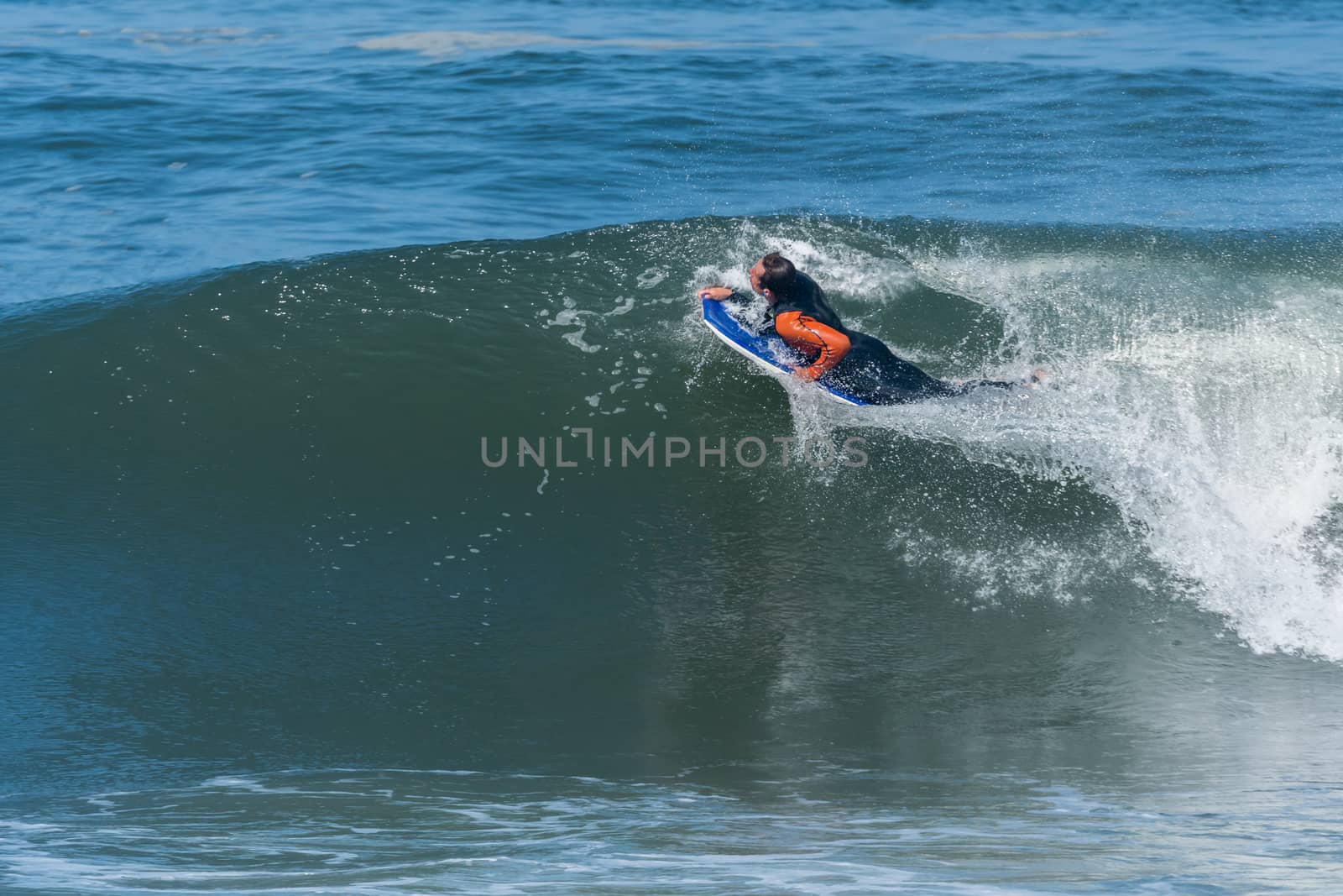 Bodyboarder in action on the ocean waves on a sunny day.