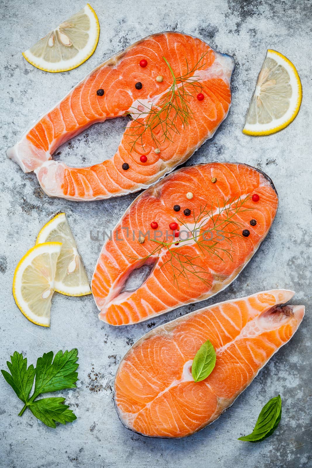 Fresh salmon fillet sliced flat lay on shabby metal background. Raw salmon fillet and ingredients parsley ,sweet basil leaves ,fennel ,pepper corn and lemon for cooking.