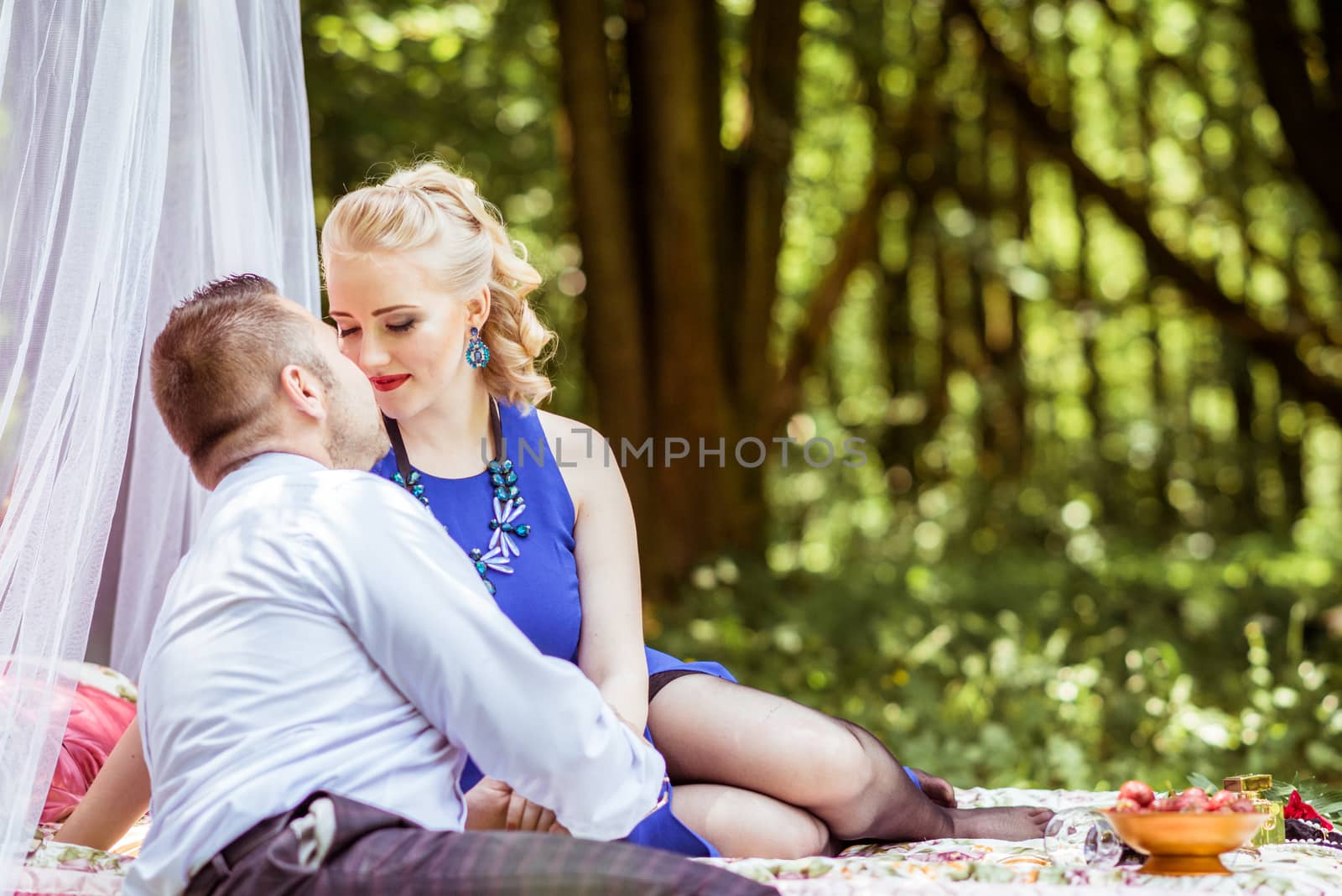 Man and woman sitting on the bed and looking at each other in the lawn in Lviv, Ukraine.