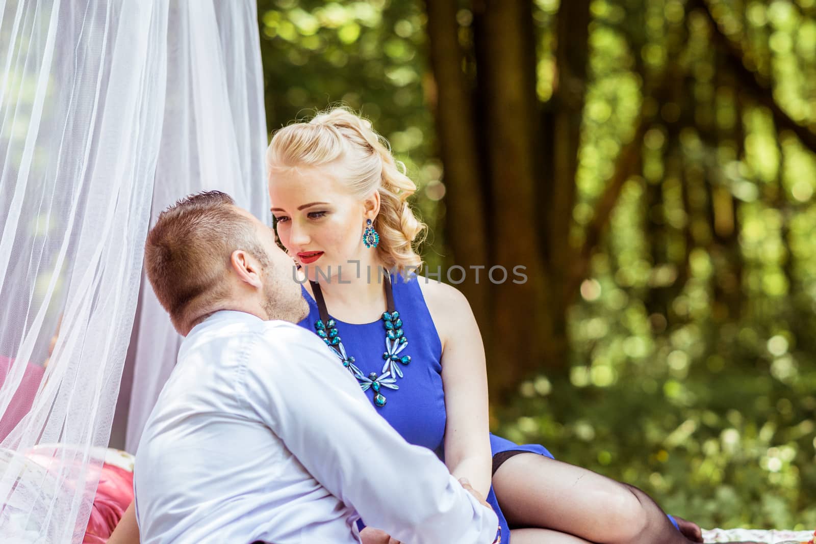 Man and woman sitting on the bed and looking at each other in the lawn in Lviv, Ukraine.