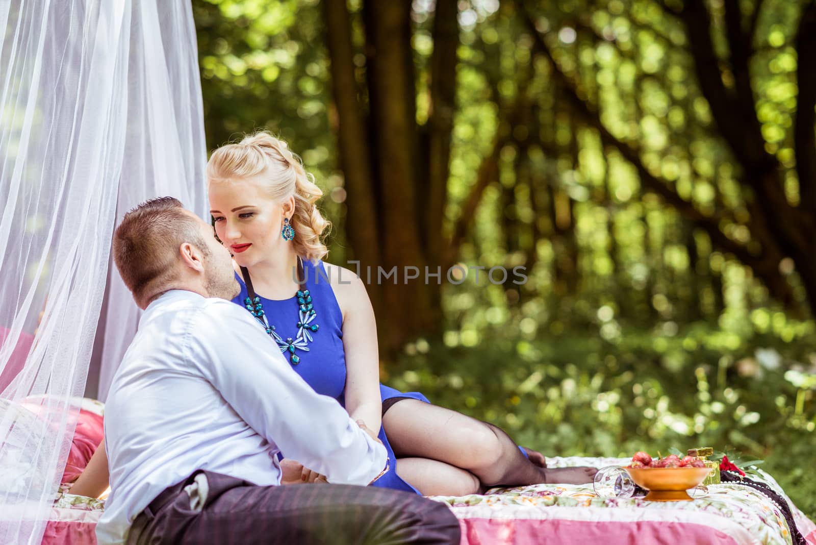 Man and woman sitting on the bed and looking at each other in the lawn in Lviv, Ukraine.