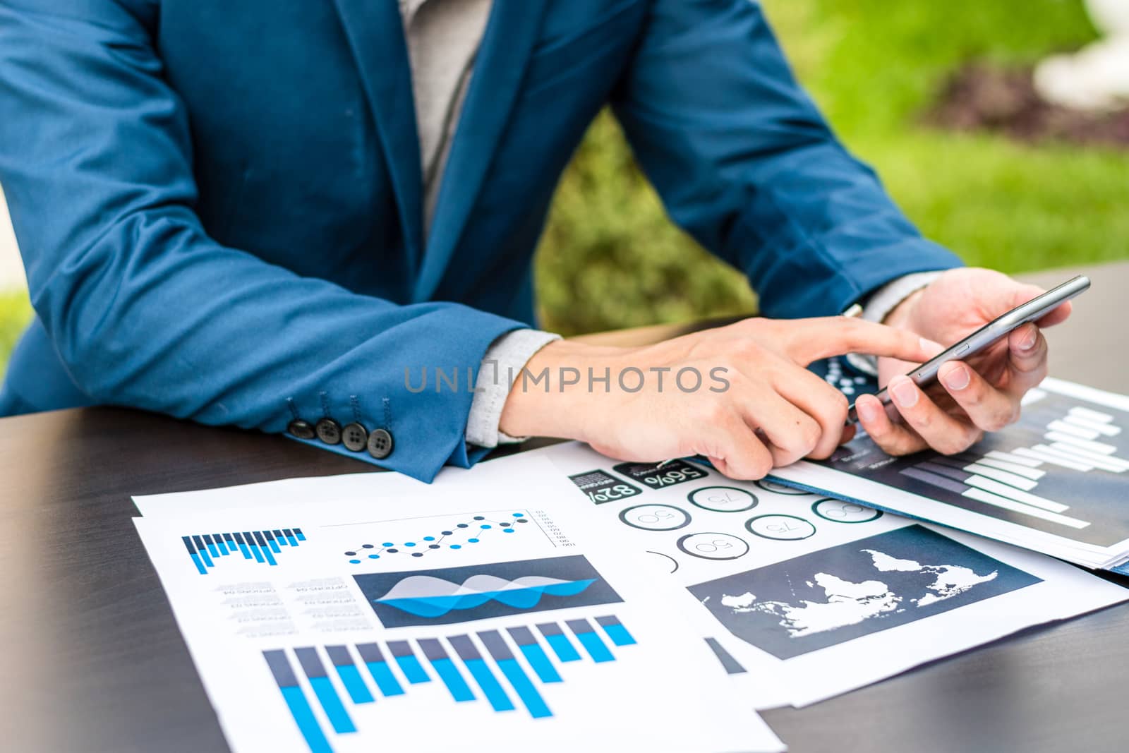 Handsome businessman wearing suit and using modern laptop outdoors and graph finance diagram.