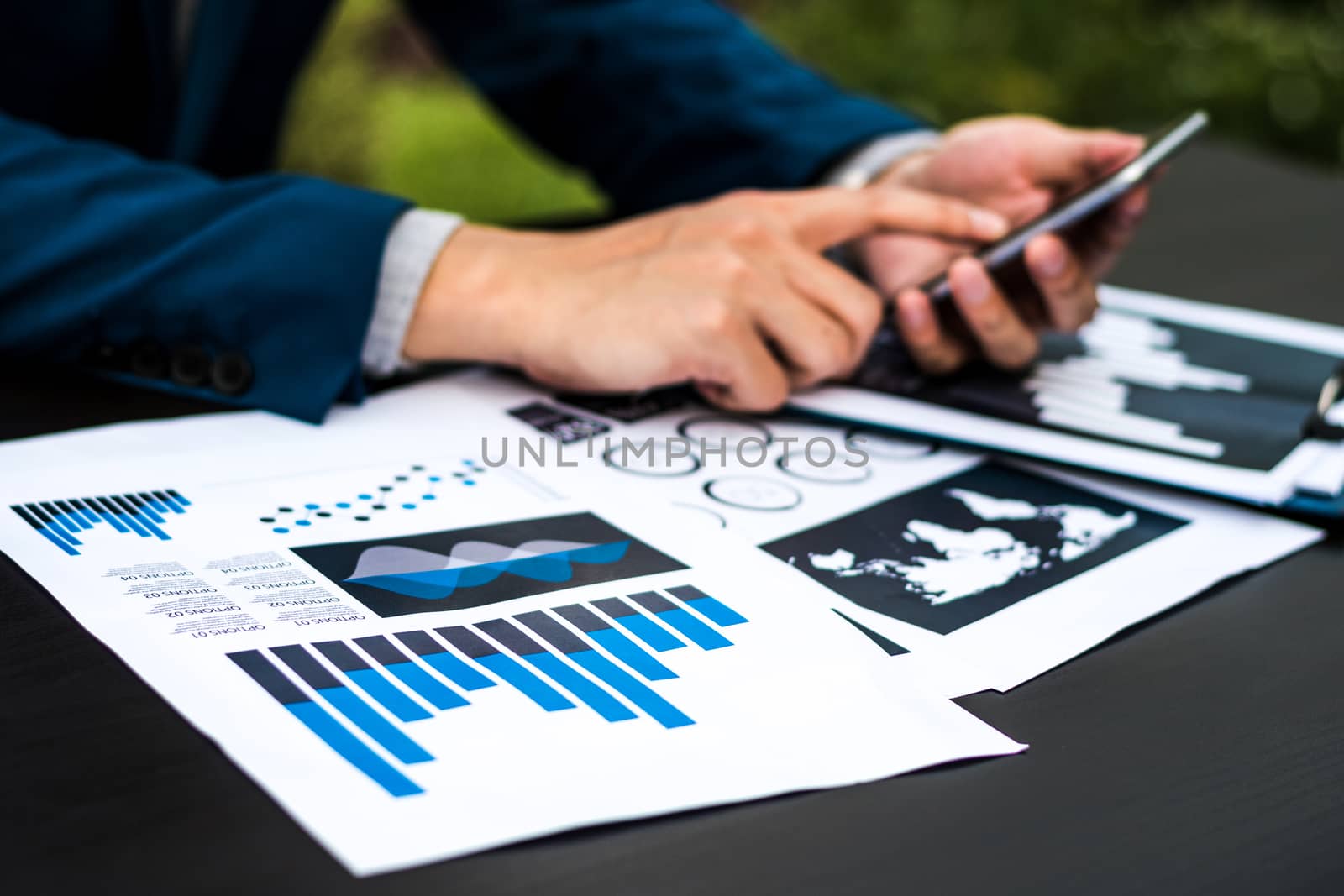 Handsome businessman wearing suit and using modern laptop outdoors and graph finance diagram.
