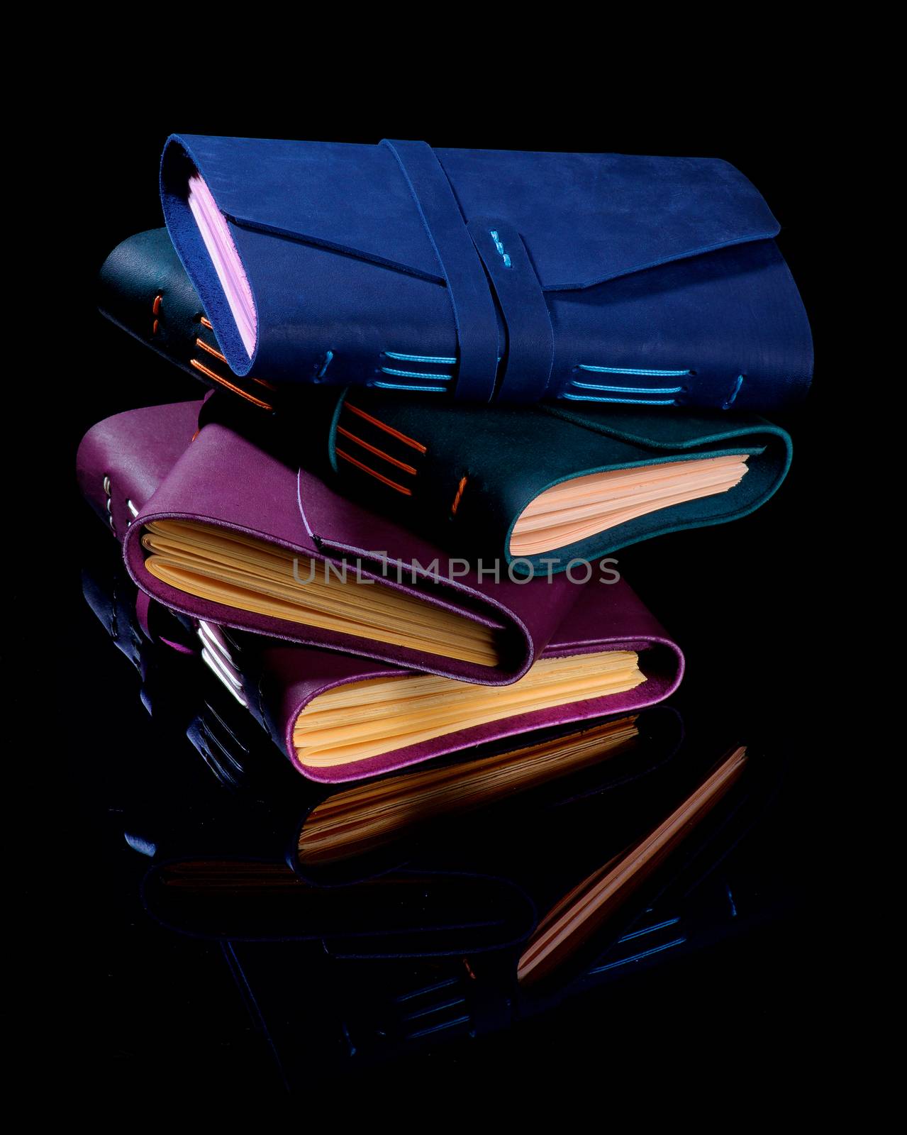 Stack of Luxury Handmade Leather Notepads with color Craft Paper isolated on Black background
