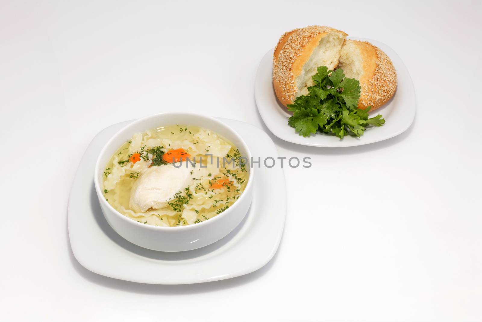 Chicken noodle soup and bun with sesame seeds and herbs