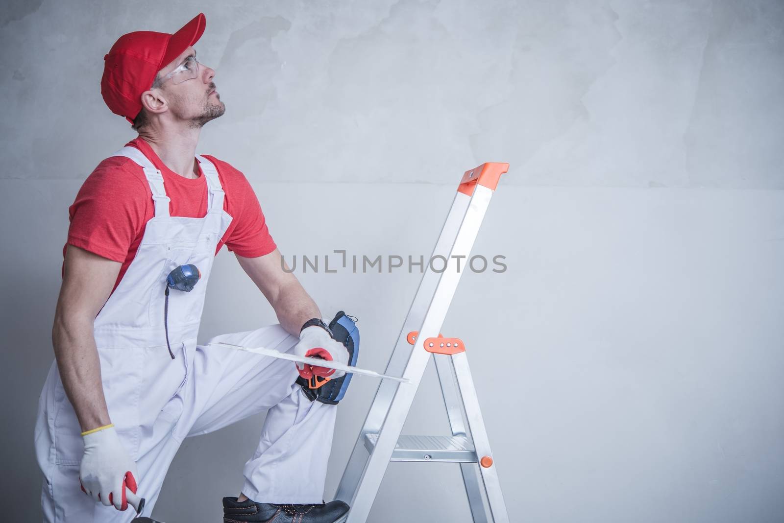 Apartment Remodeling Concept with Caucasian Construction Worker Preparing For Drywall Patching.