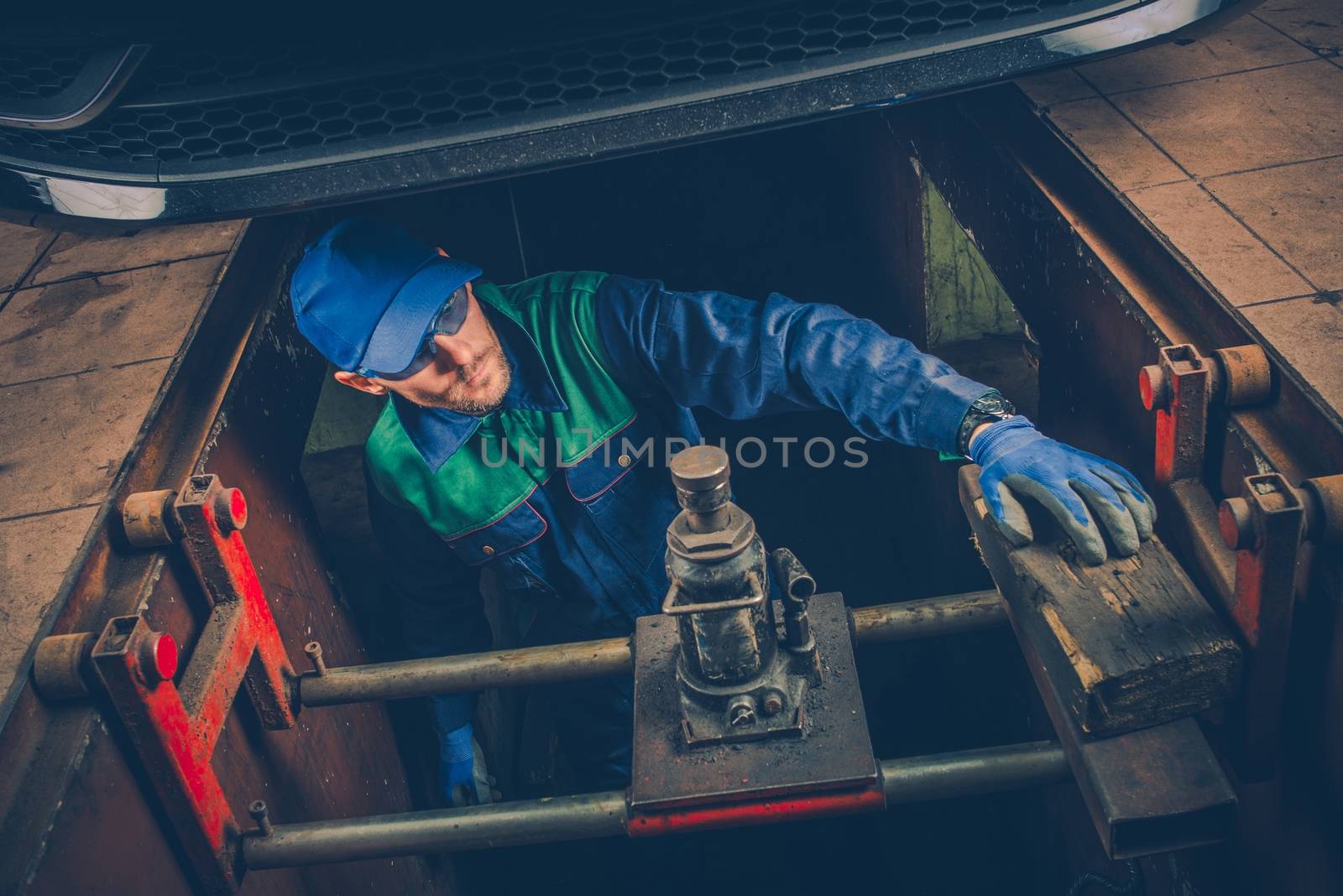 Car Mechanic Working Under the Car To Fix Vehicle Exhaust System. Car Maintenance.