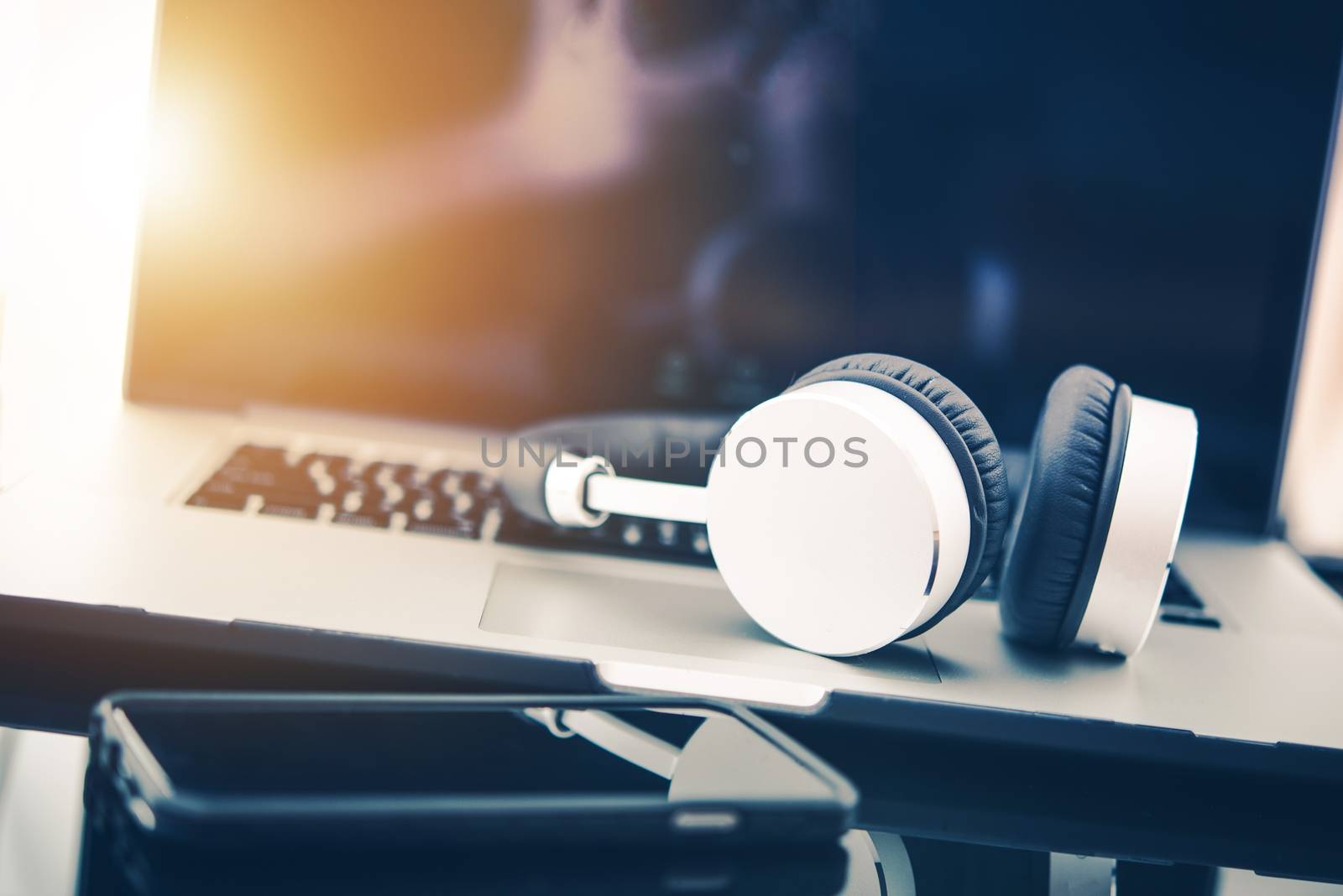 Computer in Business Concept. Laptop Computer Workstation with Wireless Headphones For Privacy and Sound Quality. Listening Relaxing Music While Working.