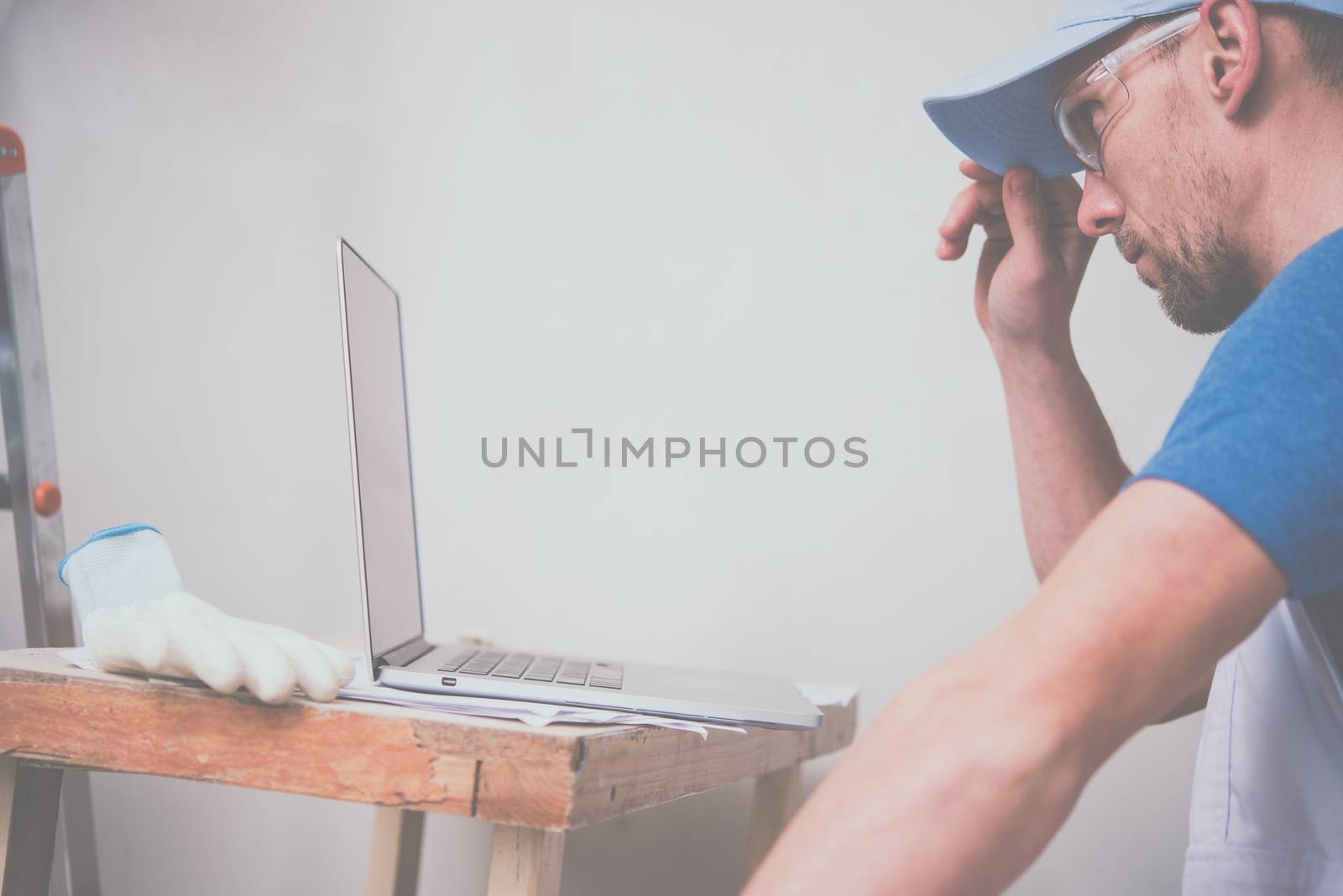 Construction Business Concept. Caucasian Worker with Laptop Computer Checking Project Schedule.