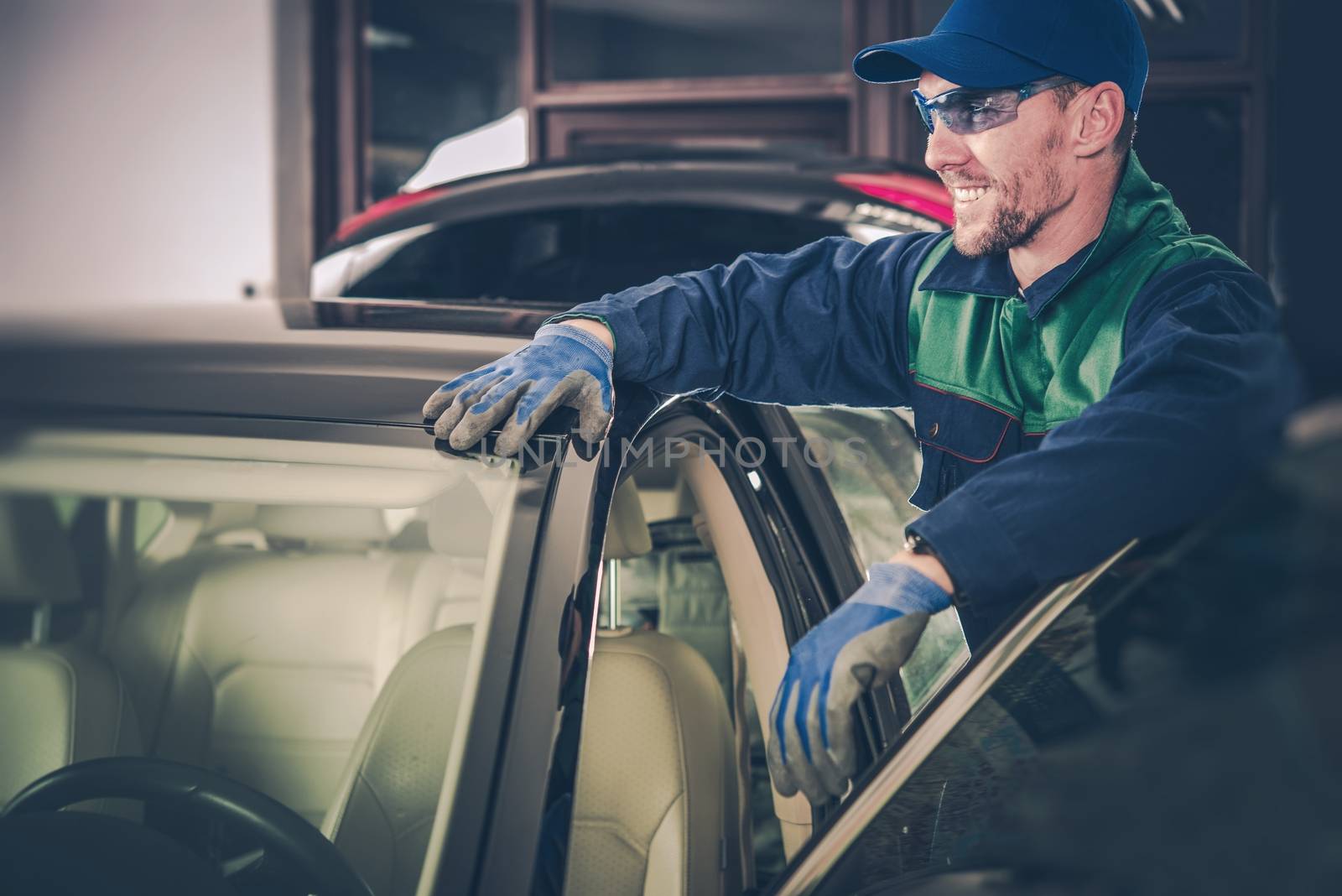 Happy Car Mechanic in His Small Garage Auto Service Shop. Small Business Concept.