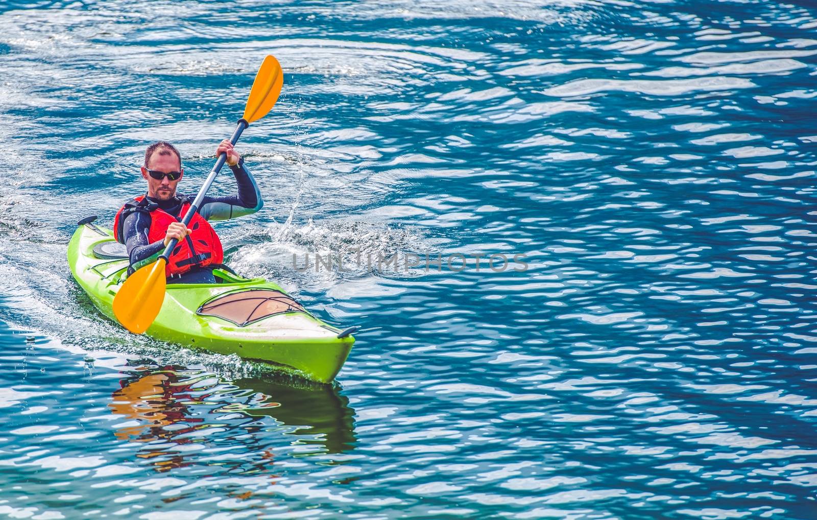 Kayak Lake Tour. Caucasian Men Paddling in the Kayak on the Lake.