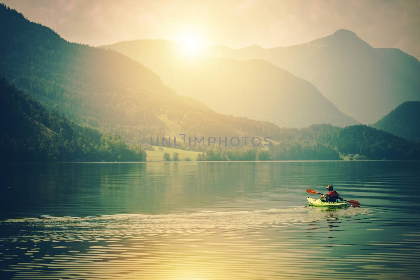 Lake Kayak Touring. Summer Recreations and Sport Photo Concept. Senior Sportsman in the Tour Kayak on the Lake.