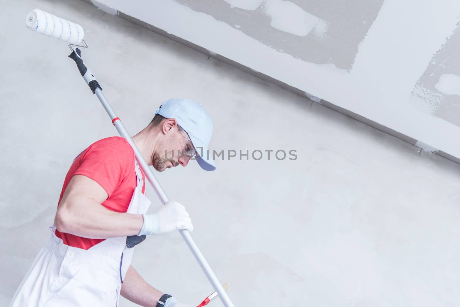 Room Painter Work to Do. Caucasian Painter in His 30s with Painting Roller Preparing For His Job.