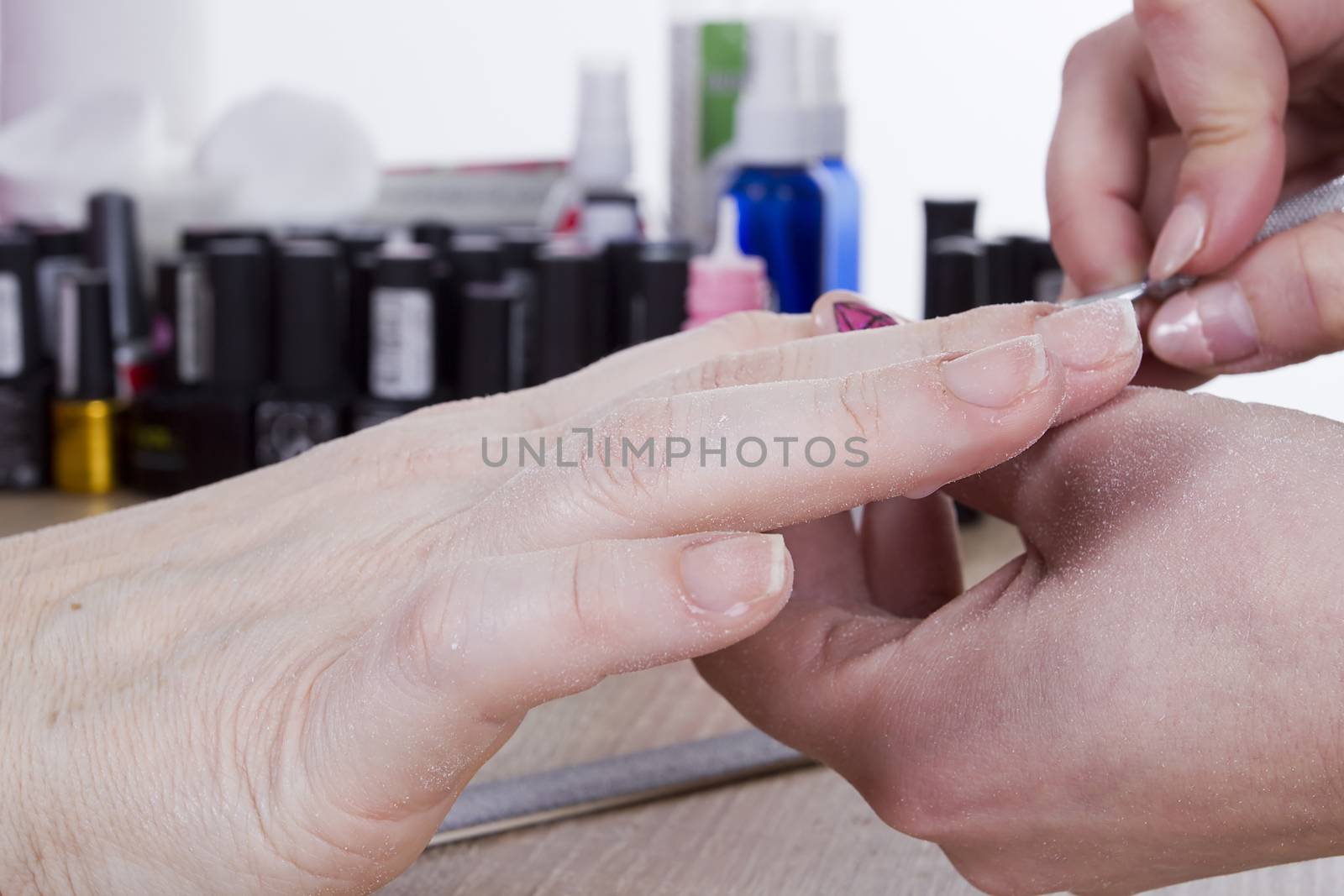 Professional manicure procedure in beauty salon. Hands close up.