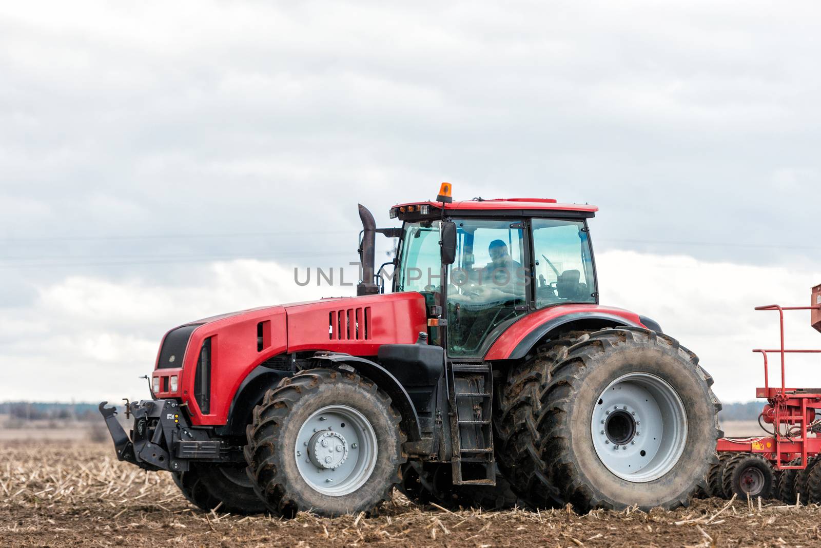 Farmer tractor working in the field. Spring time for sowing. Planting crops. 