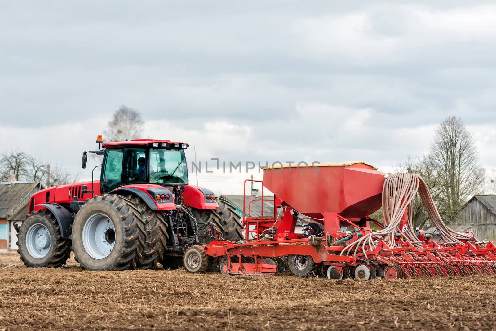 Farmer tractor working in the field. Spring time for sowing. Planting crops. 