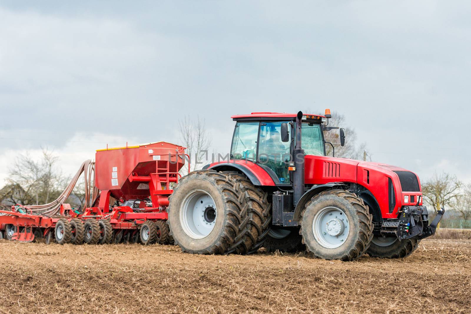 Farmer tractor working in the field. Spring time for sowing. Planting crops. 